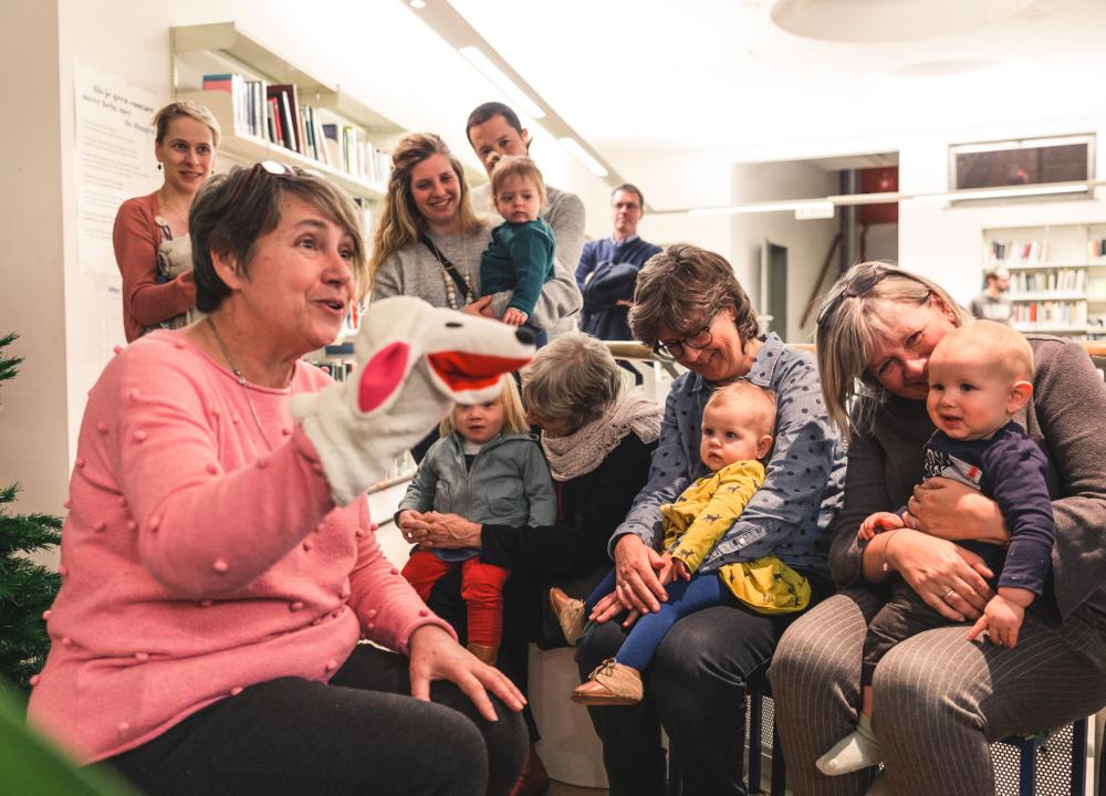 Voorleesvrijwilliger leest voor aan groep peuters